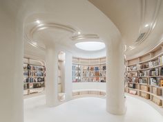 a circular room with many bookshelves and lights on the ceiling is filled with books