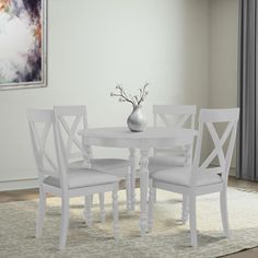 a white table with four chairs and a vase on the floor in front of it