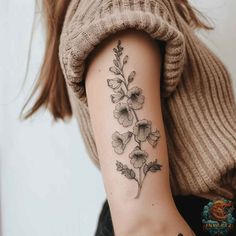 a woman's arm with a flower tattoo on the left side of her arm