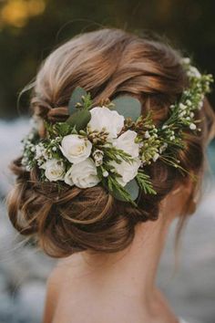 a woman with flowers in her hair is wearing a flower headpiece on her wedding day