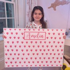 a girl holding up a sign with hearts on it