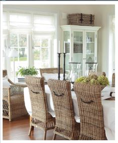 a dining room table with wicker chairs