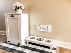 a white dog house with two bowls on the floor