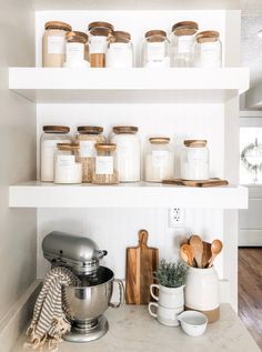 the shelves in this kitchen are filled with spices