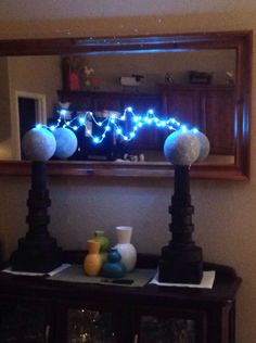 a table with some lights on it and vases in front of the mirror that is lit up