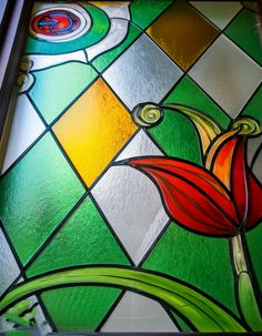 a stained glass window with a flower on it's side and an image of a bird in the center