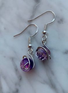 Wire wrapped earrings with purple and clear crystal beads.  Sterling silver ear wire.  Ships for free!  If your item is somehow damaged in shipping, don't hesitate to reach out to me. I will replace it immediately! It will differ slightly from the picture since my products are handmade, but I will make it as close as possible to the original. Please reach out to me with any concerns about the product before leaving a review.  I take only 1-2 business days to get my items shipped out to you. See Purple Beaded Earrings, Multicolored Earrings, French Hook Earrings, Purple Beaded, Asymmetrical Earrings, Earrings Handmade Dangle, Earrings Wire, Wrapped Earrings, Purple Earrings