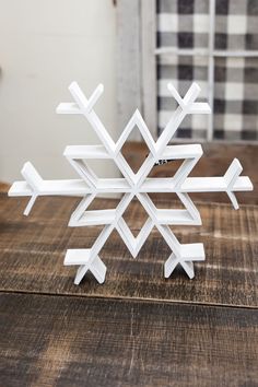 a white snowflake sitting on top of a wooden table