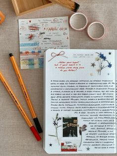 an open notebook with some writing on it and two pencils next to it, surrounded by other items