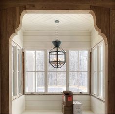 an empty room with a lantern hanging from the ceiling