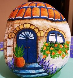 a painted rock sitting on top of a table next to a potted planter