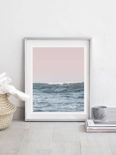 a white frame sitting on top of a wooden floor next to a basket filled with towels