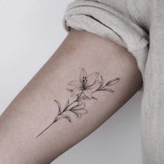 a woman's arm with a flower tattoo on the left side of her body