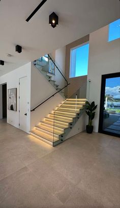 a large open floor plan with stairs leading up to the upper level and windows on both sides