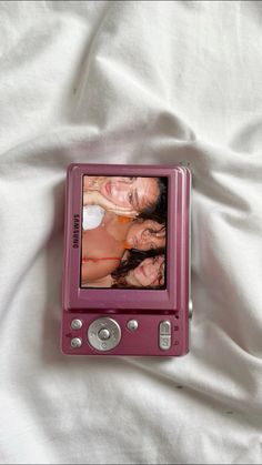 a pink electronic device sitting on top of a white sheet