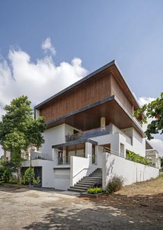 the house is white and has stairs leading up to it's second story,