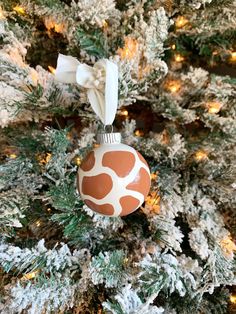 a giraffe print ornament hanging from a christmas tree