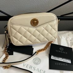 New With Dust Bag And Cards! Versace Small Gorgeous Creamy Beige “Ecru” Leather Quilted Crossbody With Gold Medusa Gold Logo Front And Center Wear As A Crossbody Camera Bag Or On The Shoulder Stunning Genuine Leather With An Ultimate Luxurious Feel Perfect For Day Or Night Strap Is Leather And Gold Chain Mix. Adjustable Strap Feature. Convenient Front Pocket. Perfect Size Fits Tons And Any Size Iphone Approximately: 8" Across 5" Tall 2" Depth Color Name Is Ecru Designer Cream Crossbody Shoulder Bag, Designer Cream Shoulder Bag With Branded Hardware, Cream Crossbody Shoulder Bag With Branded Hardware, Luxury Cream Bag With Branded Hardware, Luxury Cream Bags With Branded Hardware, Crossbody Camera Bag, Versace Pink, Versace Handbags, Quilted Wallet