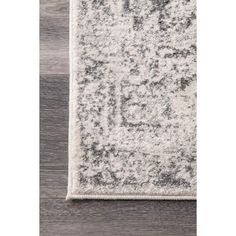 a white and gray rug on top of a wooden floor