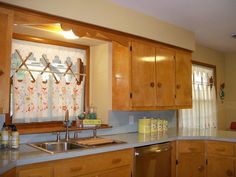 a kitchen with wooden cabinets and stainless steel sink in the center, along with an open window over the dishwasher