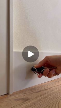 a person is opening the door with a key in their hand and there is a video playing below