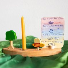 there is a small wooden toy with a note on it and a candle next to it