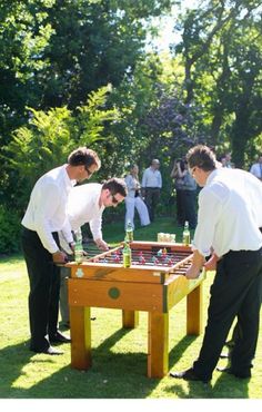 three men playing a game of chess in the grass