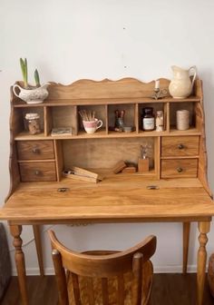 a wooden desk with two chairs next to it and a vase on the top shelf