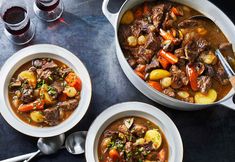 two bowls of beef stew with carrots and potatoes