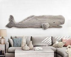 a living room filled with furniture and a large wooden fish wall hanging on the wall