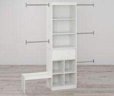 an empty white shelf with clothes hanging on it