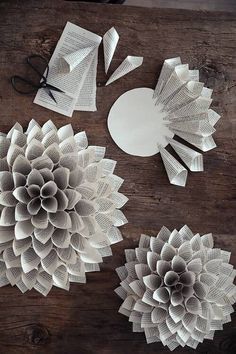 three paper flowers are sitting on a table