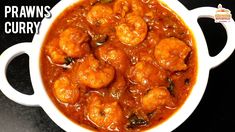 a white bowl filled with shrimp curry on top of a black counter next to a spoon