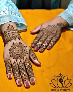 two hands with henna designs on them