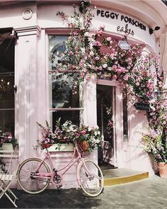 a bicycle is parked in front of a flower shop