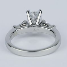 a white gold engagement ring with a princess cut diamond in the center and side stones