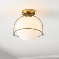 a light fixture hanging from the ceiling in a room with white walls and flooring