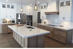 a large kitchen with white cabinets and stainless steel appliances