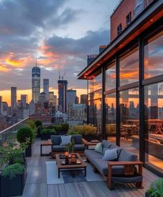 an outdoor patio with couches and tables overlooking the cityscape at sunset or dawn