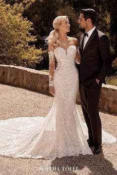 a man and woman in formal wear standing next to each other on a stone walkway