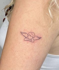 a woman's arm with a small tattoo of an angel on the left side