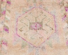 an old rug with pink, green and yellow colors on the bottom is laying flat