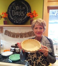 a woman holding up a pie crust in front of a sign that says no thanks