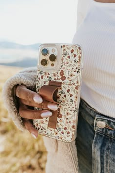 a woman holding an iphone case with a cell phone holder attached to it