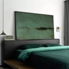 a bed with green sheets and pillows in front of a large painting on the wall