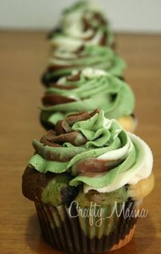 three cupcakes with green frosting and chocolate swirls