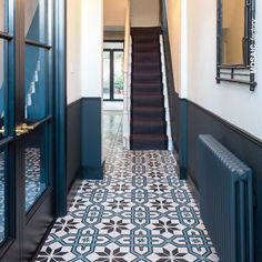 the hallway is decorated in black and white tiles with an intricate pattern on the floor