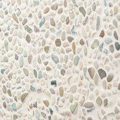 a white wall with many different colored rocks on it