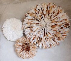 three white and brown pieces of fur sitting on top of a floor next to each other