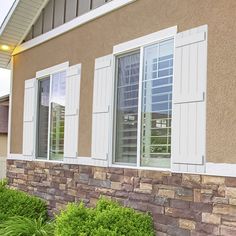 a house with white shutters on the windows